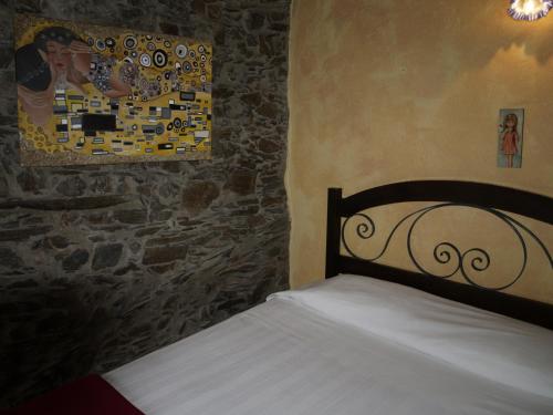 a bedroom with a bed and a painting on the wall at Casa Lausus in Lousã