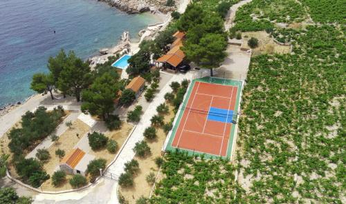 an aerial view of a tennis court next to the water at Skaramuca Village Luxury Resort in Potomje