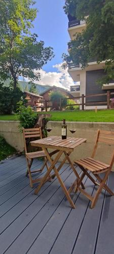 a picnic table with a bottle of wine and two chairs at Chalet Antoine serviced Apartments by Mirabeau in Zermatt