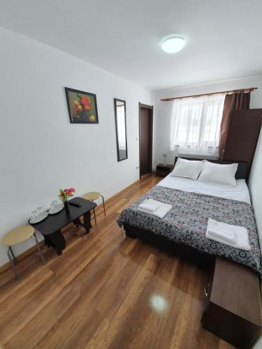 a bedroom with a bed and a table in it at Pensiunea Agroturistica ANCA&IOANA in Bălceşti