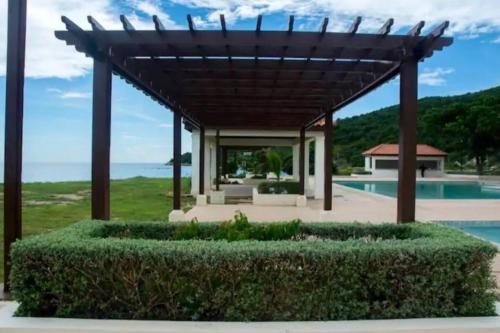 a home with a pergola and a swimming pool at Ornella Villa 2-Beds Sleeps 4 - Pool & Parking in Portmore