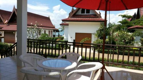 a patio with a table and chairs and an umbrella at Sunflower Villas in Ko Chang