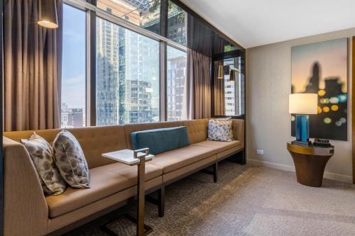 a living room with a couch and a large window at Omni Charlotte Hotel in Charlotte
