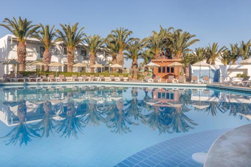 a pool at a resort with palm trees at Sol Marina Beach Crete in Gouves