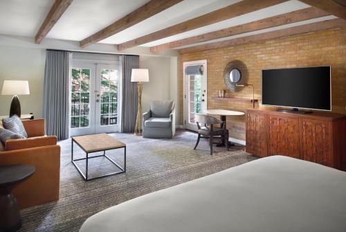 a hotel room with a bed and a flat screen tv at Omni La Mansion del Rio in San Antonio