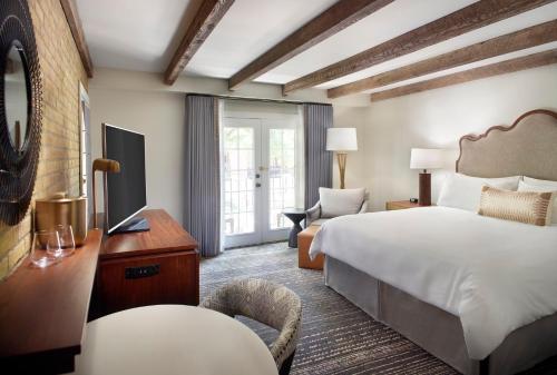 a hotel room with a large bed and a television at Omni La Mansion del Rio in San Antonio