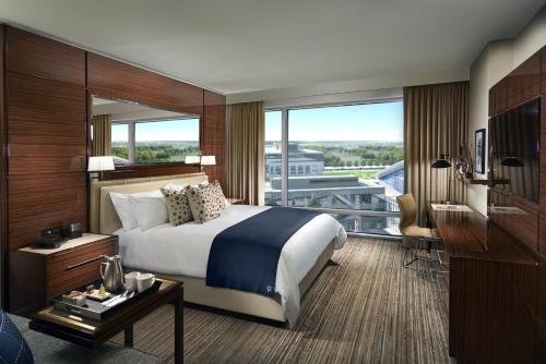 a hotel room with a bed and a large window at Omni Frisco at The Star in Frisco