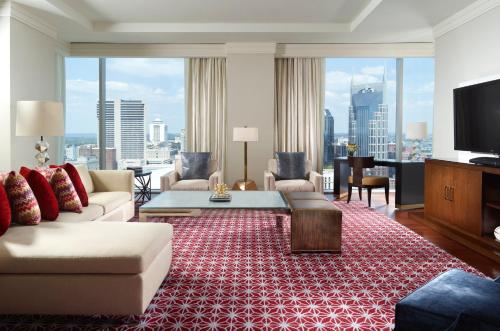 a living room with a couch and a tv at Omni Nashville Hotel in Nashville
