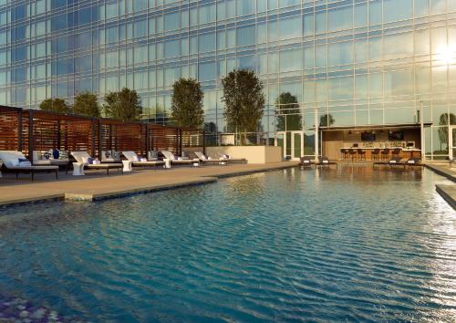 un hotel con piscina frente a un edificio en Omni Frisco at The Star en Frisco