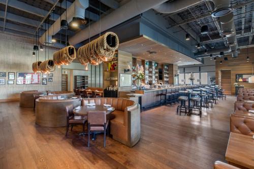 a restaurant with tables and chairs and a bar at Omni Frisco at The Star in Frisco