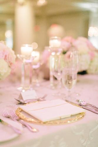 a table with a pink table cloth with plates and silverware at The Omni King Edward Hotel in Toronto