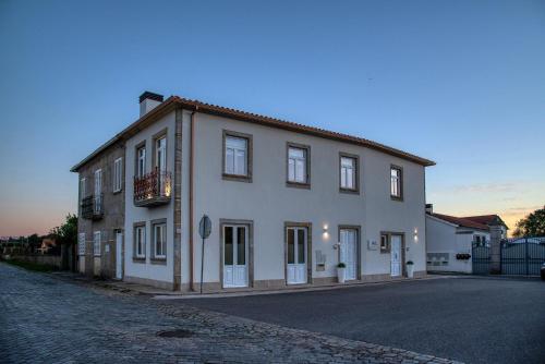 a large white building on the side of a street at Flor de Valença Guest House in Valença