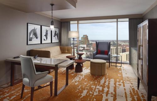 a living room with a couch and a table and chairs at Omni Louisville Hotel in Louisville