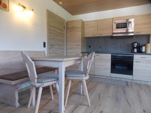 a kitchen with a table and chairs and a microwave at Ferienwohnung Dimpfl-Stad´l Fam. Lemberger in Lohberg