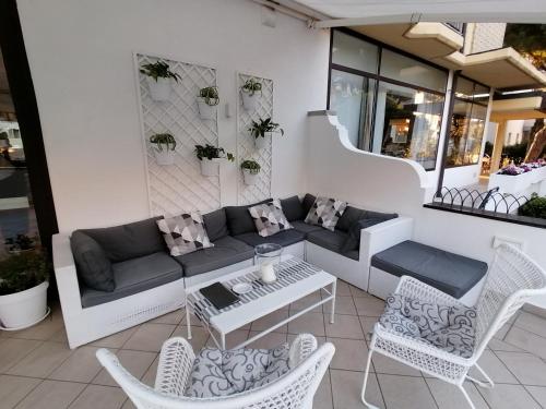 a patio with a couch and chairs and a table at Palace Hotel Regina in Bibione