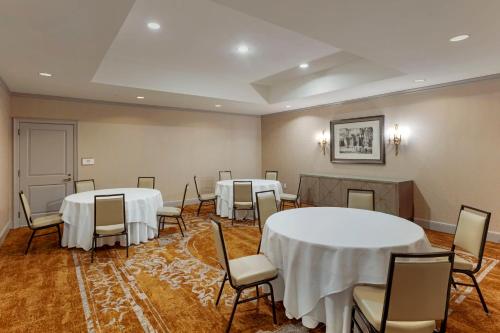 a room with two tables and chairs with white table cloth at Omni New Haven Hotel at Yale in New Haven
