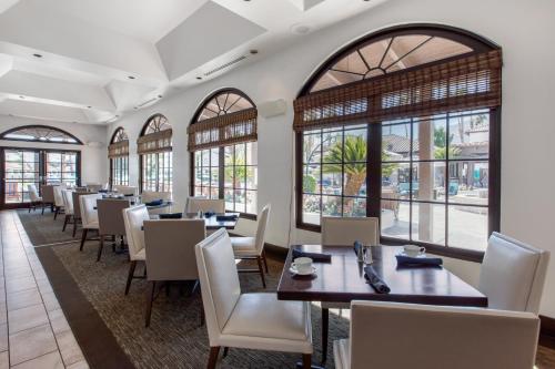 a dining room with tables and chairs and windows at Omni Rancho Las Palmas Resort & Spa in Rancho Mirage