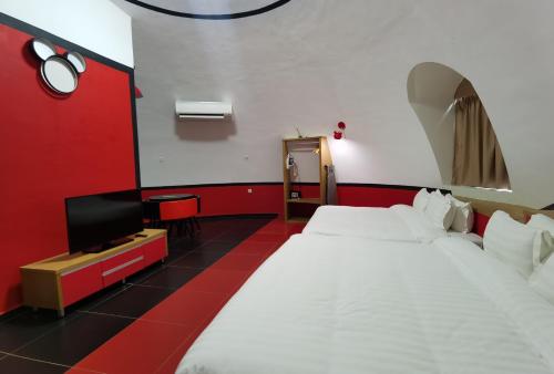 a room with two beds and a flat screen tv at MyRus Resort Langkawi in Pantai Cenang