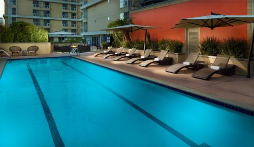 a large swimming pool with chairs and umbrellas at Omni Los Angeles Hotel in Los Angeles