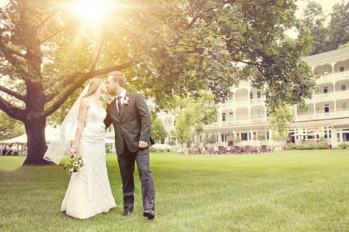 a bride and groom kissing in front of a building at Omni Bedford Springs Resort & Spa in Bedford