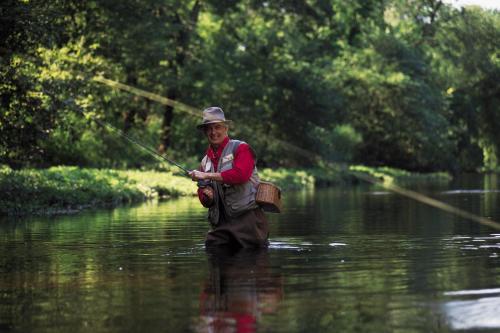 a man in the water fishing in a river at Omni Bedford Springs Resort & Spa in Bedford