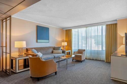 a living room with a couch and chairs in a hotel room at Omni Mont-Royal Hotel in Montréal