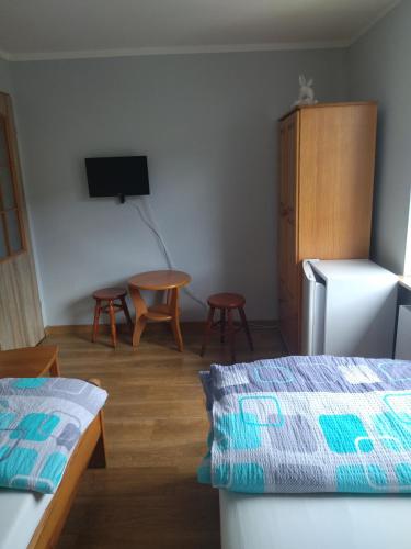 a room with a bed and a table and a refrigerator at Pokoje Gdynia Demptowo in Gdynia