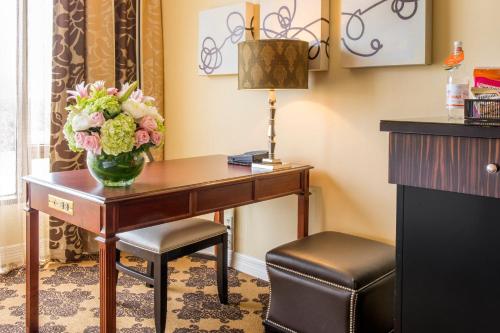 a hotel room with a desk with a vase of flowers at Omni Houston Hotel in Houston