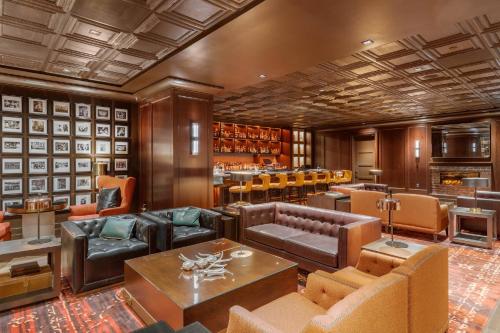 a lobby with leather furniture and a bar at Omni Houston Hotel in Houston