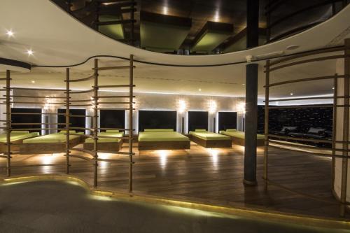a room with green beds and a spiral staircase at SPA & Relax Hotel Erika in Tirolo