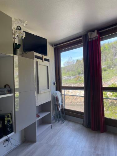 a room with a large window with a view at STUDIO aux pieds des pistes - Villard de Lans - Cote 2000 in Villard-de-Lans