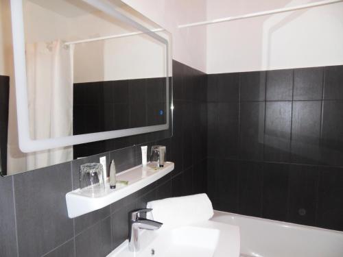 a bathroom with a sink and a mirror at Hôtel du Verdon in Beauvezer