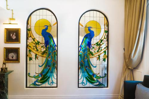 two stained glass windows with peacocks on a wall at Magnova Vitality Boutique Hotel in Istanbul