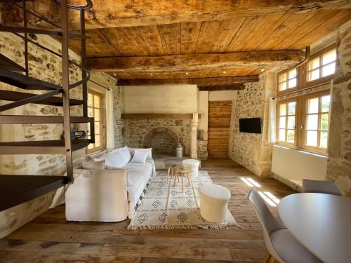 a living room with a white couch and a fireplace at Domaine de Gressac in Verfeuil