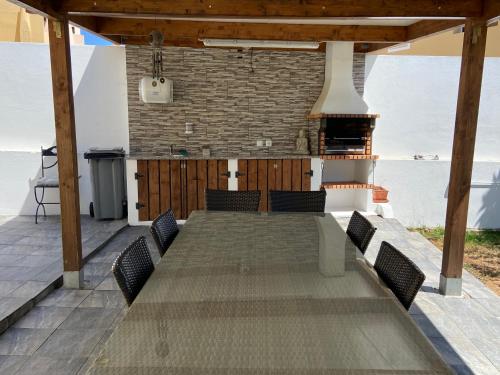 a large wooden table with chairs on a patio at Vivenda Sossego do Mar in Ferragudo