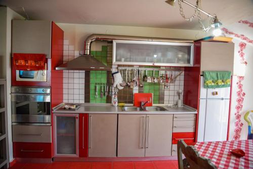 a kitchen with red and green walls and a sink at Villa Papavero in Maronia