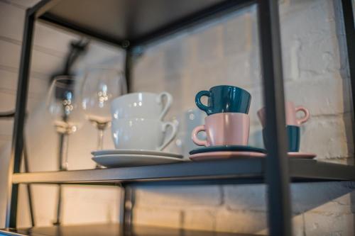 a glass shelf with plates and cups and wine glasses at Apartamenty Rymanów in Rymanów