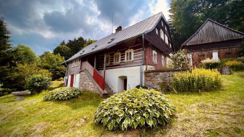 a large wooden house on a grassy field at Chata Josef in Rokytnice nad Jizerou