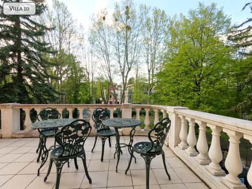 a patio with tables and chairs on a balcony at Gosztonyi Villa in Siófok