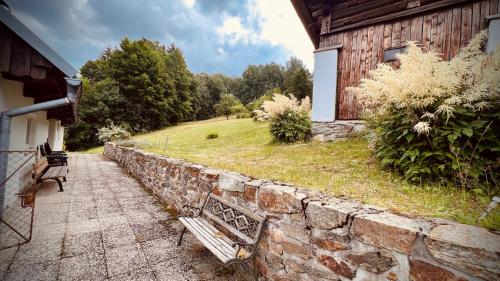 a bench sitting on a stone wall next to a building at Chata Josef in Rokytnice nad Jizerou