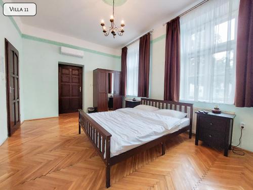 a bedroom with a bed and a chandelier at Gosztonyi Villa in Siófok