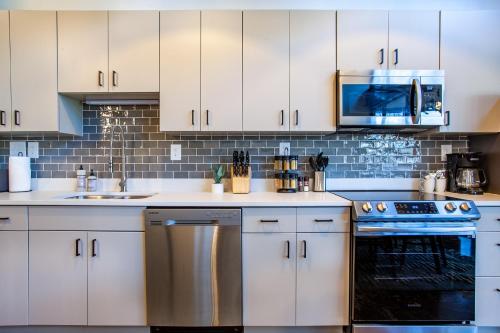 a kitchen with white cabinets and blue appliances at Urban Sterchi Lofts - Downtown Knoxville in Knoxville