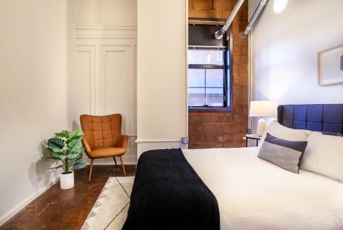 a bedroom with a bed and a chair at Urban Sterchi Lofts - Downtown Knoxville in Knoxville