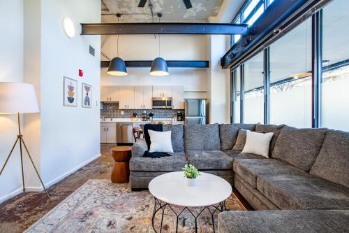 a living room with a couch and a table at Urban Sterchi Lofts - Downtown Knoxville in Knoxville