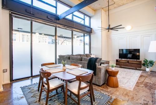 a living room with a table and a couch at Urban Sterchi Lofts - Downtown Knoxville in Knoxville