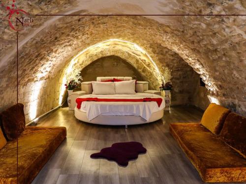ein Schlafzimmer mit einem großen Bett in einem Steintunnel in der Unterkunft Narlı Ev Butik Otel in Şanlıurfa