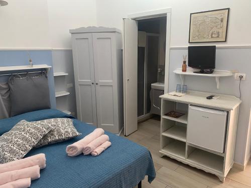 Un dormitorio con una cama azul con toallas rosas. en Il Cancello, en Matera