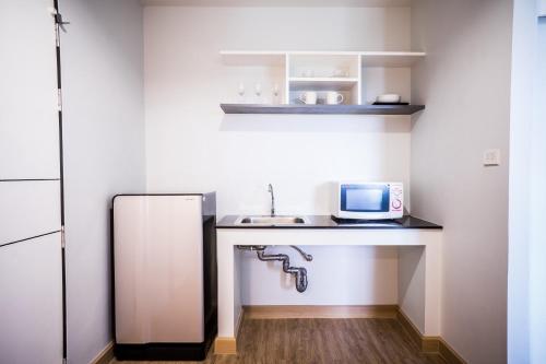 a small kitchen with a sink and a microwave at Vanilla Residence Chiangmai in Chiang Mai