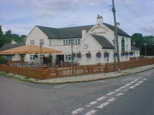 a white building with a fence in front of it at The Four Alls Inn in Market Drayton