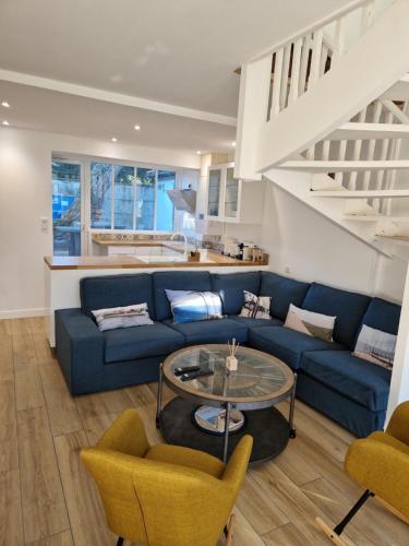 a living room with a blue couch and a table at Villa Bagatelle à 300m de la plage centrale, 3 chambres in Arcachon